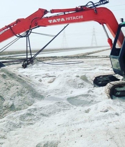 Excavator handling industrial salt at Gujarat salt works